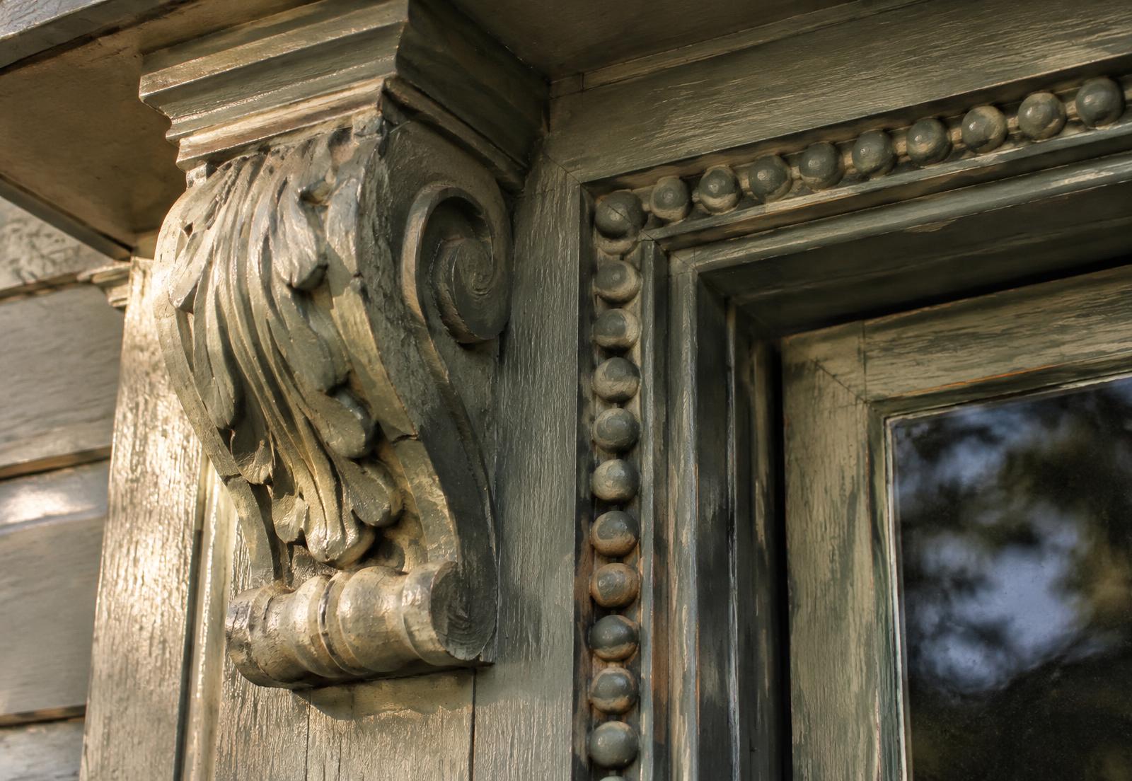 Hand-carved corbel and beaded casing on a traditional entry