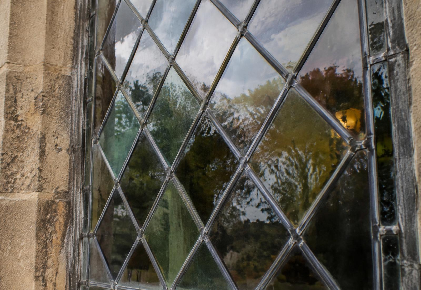Leaded diamond-pane glass set into a hand-cut stone surround